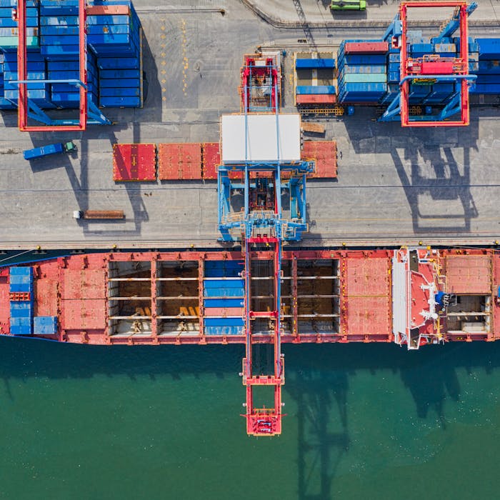 Aerial view of cargo ship near international shipping containers